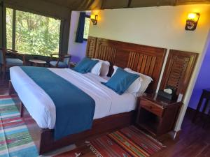 a bedroom with a large bed with blue pillows at Ol Muteita Lodge in Nakuru