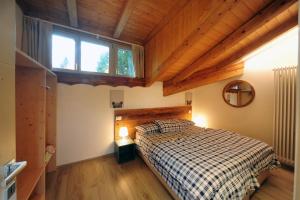 a bedroom with a bed and a window in a room at Appartamenti Residence Lares Ossana in Fucine