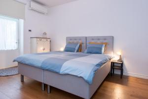 a bedroom with a large bed with blue sheets at Sunny Terrace Flat with AC Free WiFi Self Check In in Pärnu