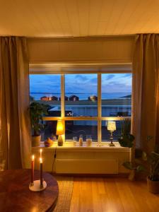 Charming coastal house with an ocean view في Garten: غرفة بها نافذة بها شمعتين على طاولة