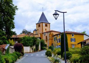 a building with a tower and a street light at Petite maison dans le beaujolais 