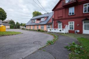 an empty street in front of a red house at Sunny Terrace Flat with AC Free WiFi Self Check In in Pärnu