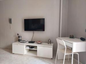 a living room with a white desk and a television on a wall at Apartamento Iceberg in Tazacorte
