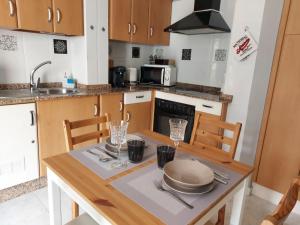 a kitchen with a table and chairs and a sink at Apartamento Iceberg in Tazacorte +16 photos