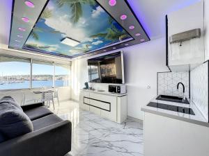 a kitchen with a ceiling with a painting of a beach at 240 Magnifique Appart Deluxe vue mer in Cap d'Agde