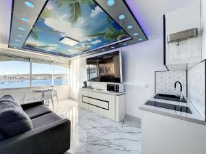 a kitchen with a ceiling with a painting of palm trees at 240 Magnifique Appart Deluxe Hammam vue mer in Cap d'Agde