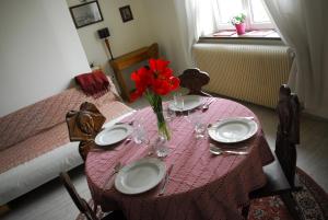 a table with a red flower in a vase on it at Ravissant 3P 90m2 au calme, proche du parlement européen in Strasbourg