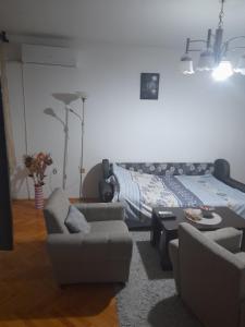 a living room with a bed and a couch and chairs at Devetka in Pirot