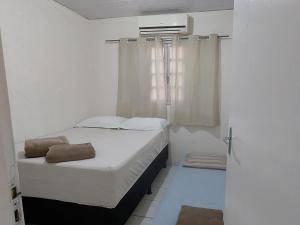 a small bedroom with a bed and a window at Casa temporada Araçoiaba in Araçoiaba