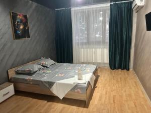 a bedroom with a bed and a window with green curtains at Apartament regim hotelier 1 camera in Galaţi