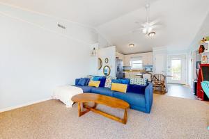 sala de estar con sofá azul y mesa en Cap'n Stilts, en Hatteras
