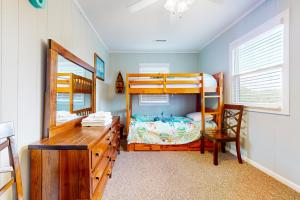 a bedroom with two bunk beds and a desk at Cap'n Stilts in Hatteras