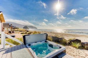 a hot tub on the beach with the ocean in the background at Neskowin Beach Escape in Neskowin