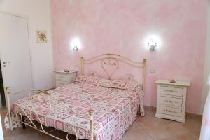 een roze slaapkamer met een bed en twee nachtkastjes bij B&B Le Rose in Olbia