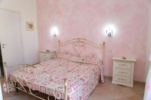 a pink bedroom with a bed and two night stands at B&B Le Rose in Olbia