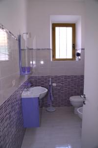 een badkamer met een wastafel en een toilet bij B&B Le Rose in Olbia