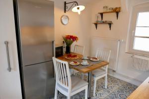 Il comprend une cuisine équipée d'une table, de chaises et d'un réfrigérateur. dans l'établissement Wohnen im ehemaligen Stall, à Wiedensahl