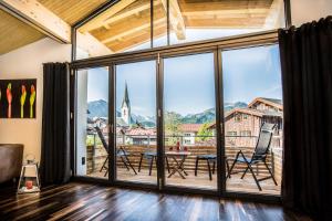 a room with a large window and a table and chairs at N6 Oberstdorf in Oberstdorf