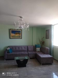 a living room with a couch and a chandelier at DEPARTAMENTO EN YANAHUARA 3er piso in Arequipa