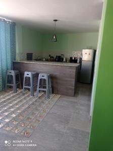 a kitchen with a counter with two stools and a refrigerator at DEPARTAMENTO EN YANAHUARA 3er piso in Arequipa