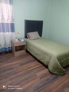 um quarto com uma cama e uma mesa de cabeceira com uma cama sidx sidx em DEPARTAMENTO EN YANAHUARA 3er piso em Arequipa