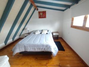 1 dormitorio con 1 cama con rayas azules y blancas en Cabañas Epuyen en Trevelín