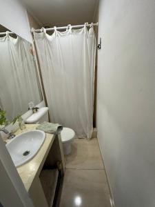 a white bathroom with a sink and a toilet at Loft en Las Flores in Las Flores