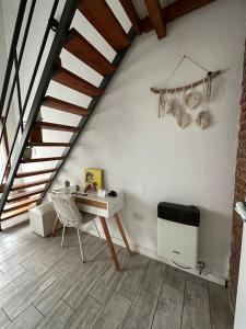 a white room with a desk and a staircase at Loft en Las Flores in Las Flores