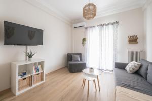 uma sala de estar com um sofá e uma mesa em Irodis at Koukaki By Greece Apartment em Atenas