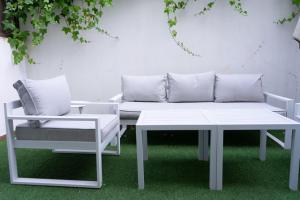 een witte bank en een tafel en een stoel bij Apartamentos Brillante 156 in Córdoba