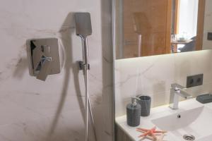 een badkamer met een douche, een wastafel en een spiegel bij Apartamentos Brillante 156 in Córdoba