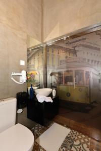 a bathroom with a toilet and a sink with a train mural at Sao Jorge Apartments & Suites in Lisbon