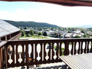 a wooden balcony with a view of a town at Appartement 2/4 personnes in Bolquere Pyrenees 2000