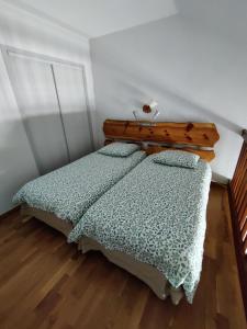 a bedroom with two beds and a wooden headboard at Appartement 2/4 personnes in Bolquere Pyrenees 2000