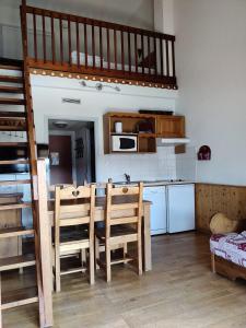 cocina con mesa, sillas y microondas en Appartement 2/4 personnes en Bolquere Pyrenees 2000