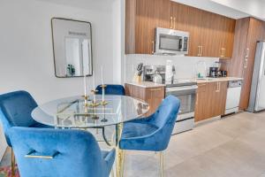 a kitchen with a glass table and blue chairs at Beautiful Property with King Bed & Free Parking in Miami