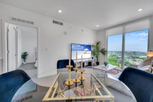 a living room with a glass table and blue chairs at Beautiful Property with King Bed & Free Parking in Miami
