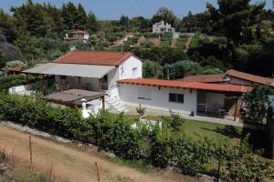 a white house with a red roof on a hill at Dimitra's Country House in Forest and Sea (2) in Metamorfosi