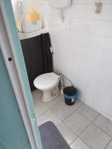 a bathroom with a toilet and a bucket in it at Pousada do Goiano in Cabo Frio