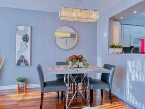 una mesa de comedor con sillas y un arreglo floral. en Fully furnished Townhome with Driveway Near DT, en Ottawa