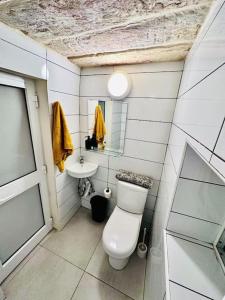 a small bathroom with a toilet and a sink at Town House 91 in Victoria