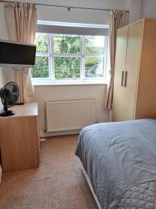 a bedroom with a bed and a large window at Beautiful studio in Ely in Ely