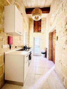 a stone kitchen with a sink and a stove at Town House 91 in Victoria
