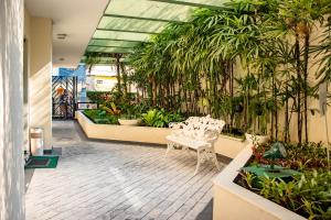 聖保羅的住宿－日內瓦公寓式酒店，里面有一个温室,里面种有植物,有白色的椅子