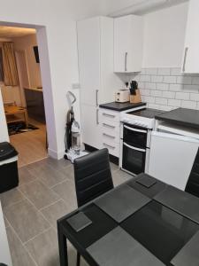 uma cozinha com uma mesa e um fogão forno superior em North Parade Holiday Apartment 35 Sea View Road Skegness PE25 1BS em Skegness