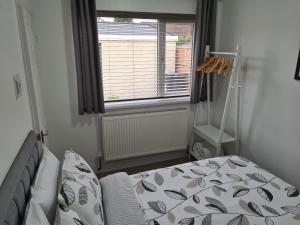 a small bedroom with a bed and a window at North Parade Holiday Apartment 35 Sea View Road Skegness PE25 1BS in Skegness
