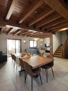 uma sala de jantar com uma grande mesa de madeira e cadeiras em Casa Baronia La Cerdanya em Puigcerdà