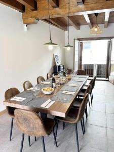 a dining room with a large wooden table and chairs at Casa Baronia La Cerdanya in Puigcerdà