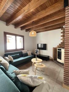 uma sala de estar com um sofá azul e uma mesa em Casa Baronia La Cerdanya em Puigcerdà