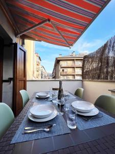 - une table avec des assiettes, des verres et une bouteille de vin dans l'établissement Casa Baronia La Cerdanya, à Puigcerdà